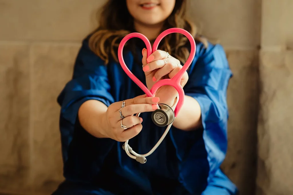 Woman holding stethoscope into a heart