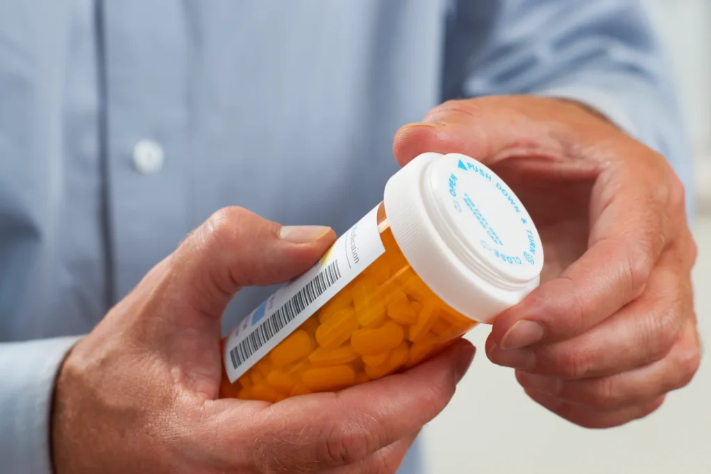 A man holding a prescription pill bottle
